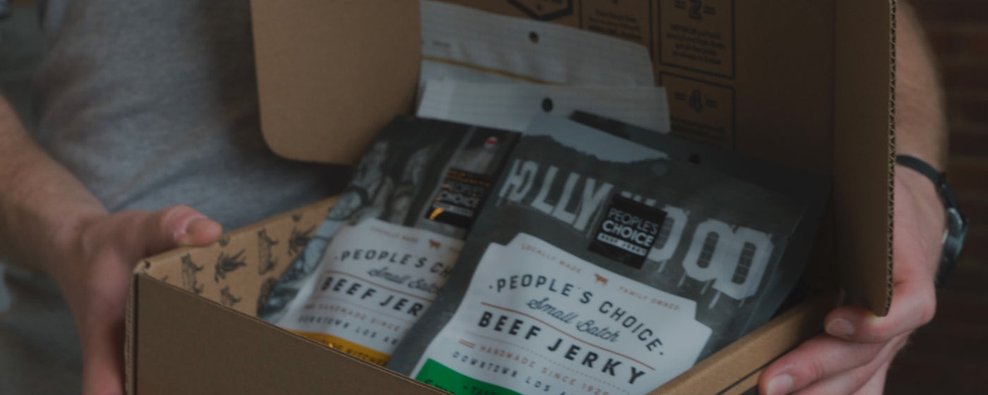 Holding a box of jerky with different flavors