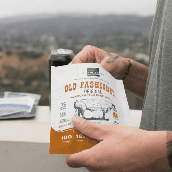 Person holding a bag of Old Fashioned beef jerky with a scenic background
