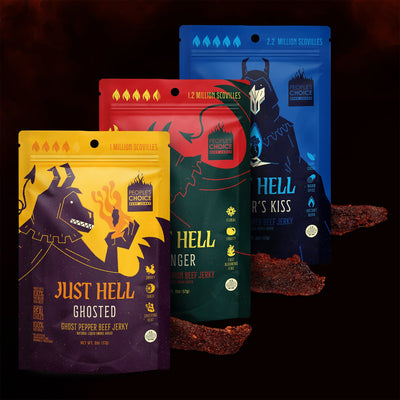Three packages of 'Just Hell' branded spicy beef jerky with colorful designs on a dark background.