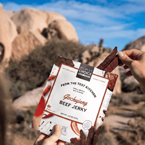 Girl holding Gochujang beef jerky in desert. 